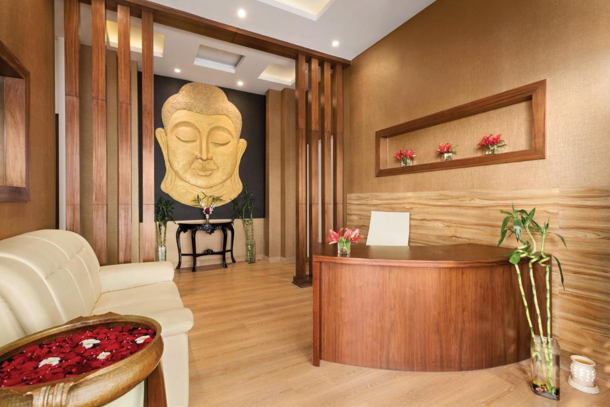 a living room with a large statue of a head on the wall at Saura Hotel, Agra - A Club Mahindra Associate in Agra