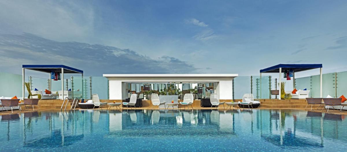 a large swimming pool with chairs on a building at The Park Chennai in Chennai a large swimming pool with chairs on a building at The Park Chennai in Chennai