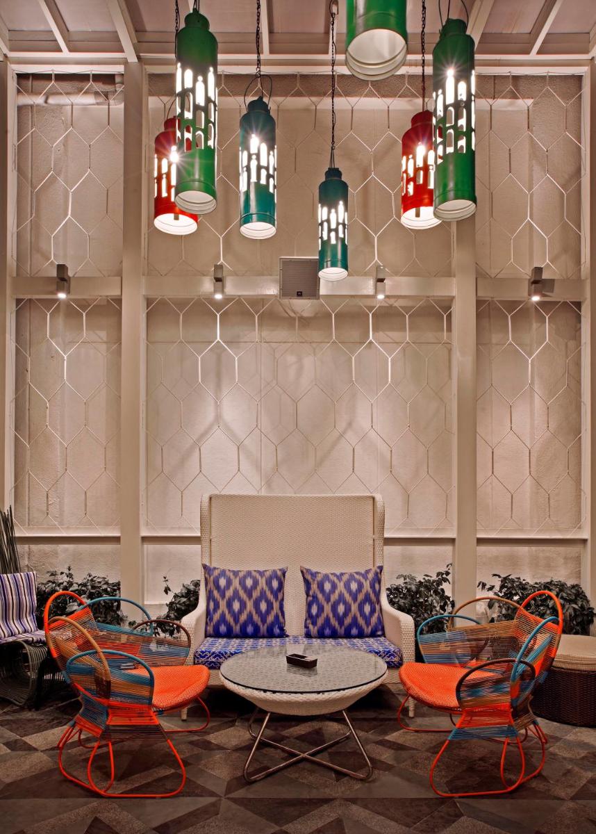 a lobby with chairs and a table and chandeliers at The Park Bangalore, MG Road in Bengaluru a lobby with chairs and a table and chandeliers at The Park Bangalore, MG Road in Bengaluru