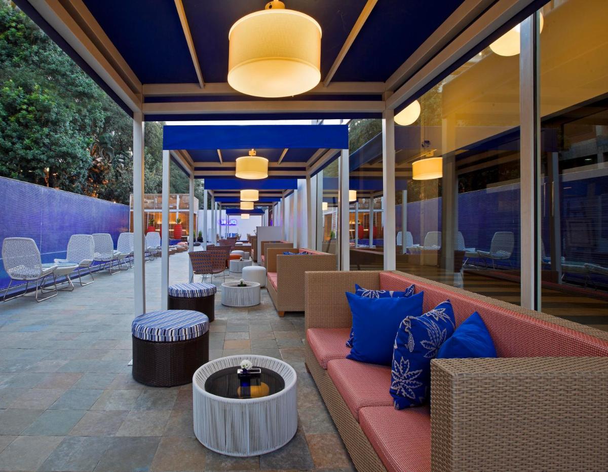 a patio with a couch and tables and chairs at The Park Bangalore, MG Road in Bengaluru a patio with a couch and tables and chairs at The Park Bangalore, MG Road in Bengaluru