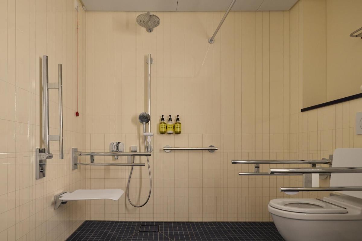 ein Badezimmer mit Dusche und Toilette in der Unterkunft Kimpton Main Frankfurt by IHG in Frankfurt am Main + 77 Fotos