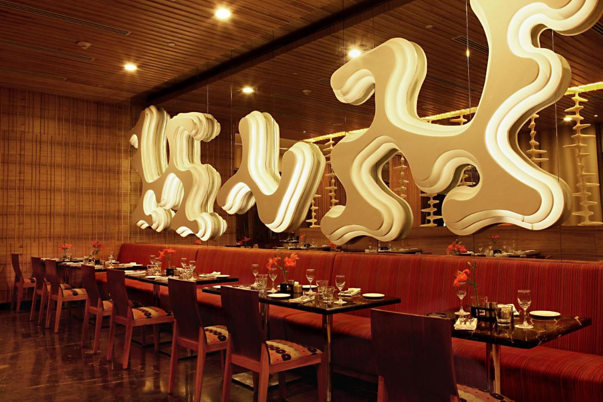 a restaurant with a long table with chairs and large letters at The Metropolitan Hotel & Spa New Delhi in New Delhi