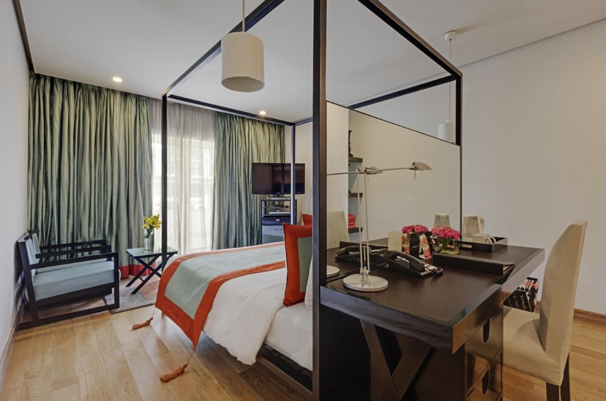 a hotel room with a bed and a desk and a desk at The Park Bangalore, MG Road in Bengaluru a hotel room with a bed and a desk and a desk at The Park Bangalore, MG Road in Bengaluru