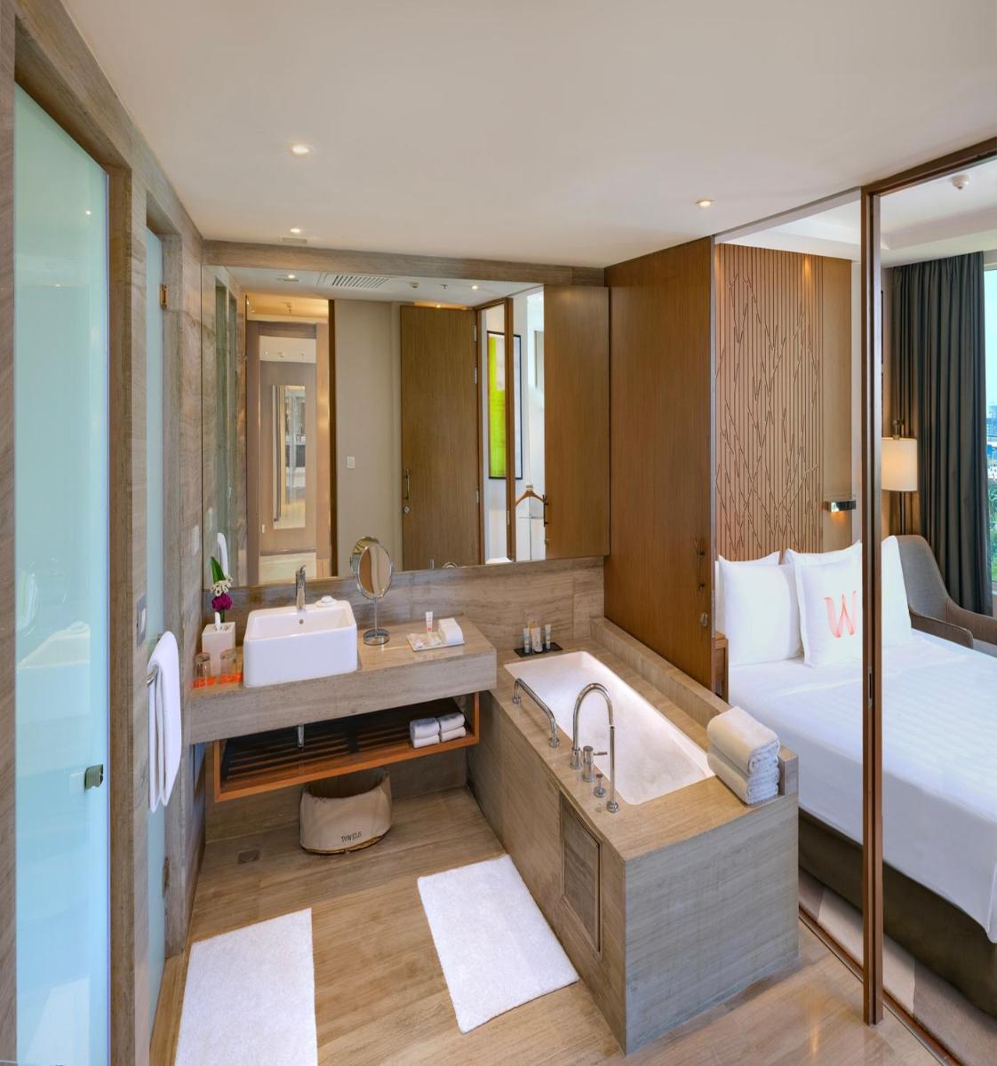 a hotel bathroom with a tub and a bed at Welcomhotel by ITC Hotels, Richmond Road, Bengaluru in Bengaluru