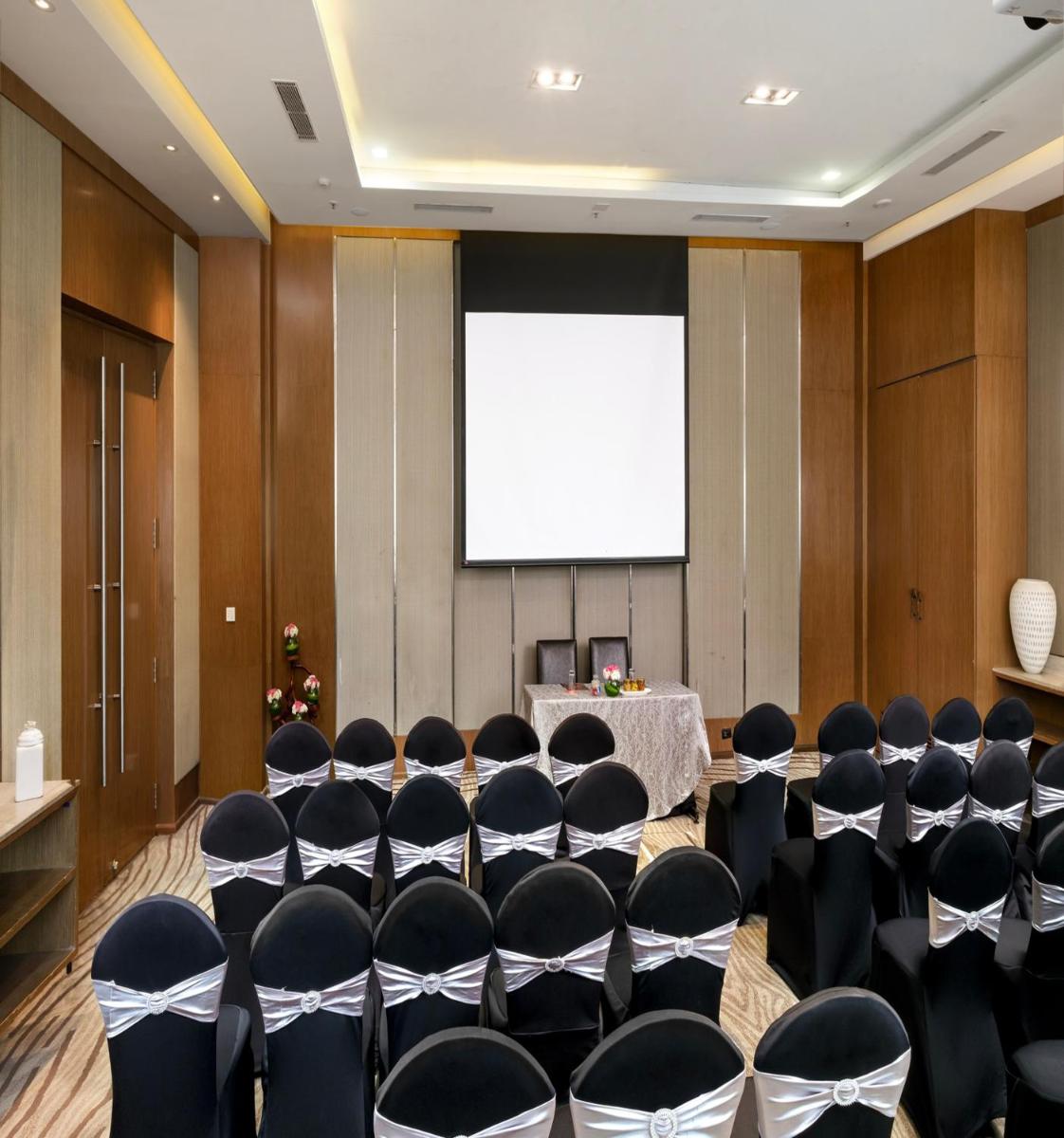 a conference room with chairs and a projection screen at Welcomhotel by ITC Hotels, Richmond Road, Bengaluru in Bengaluru
