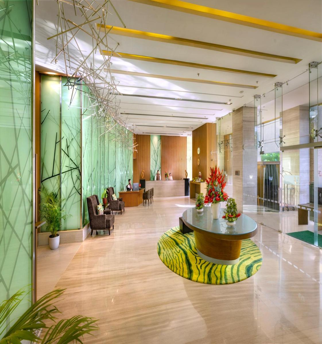 a lobby with a table in the middle of a building at Welcomhotel by ITC Hotels, Richmond Road, Bengaluru in Bengaluru