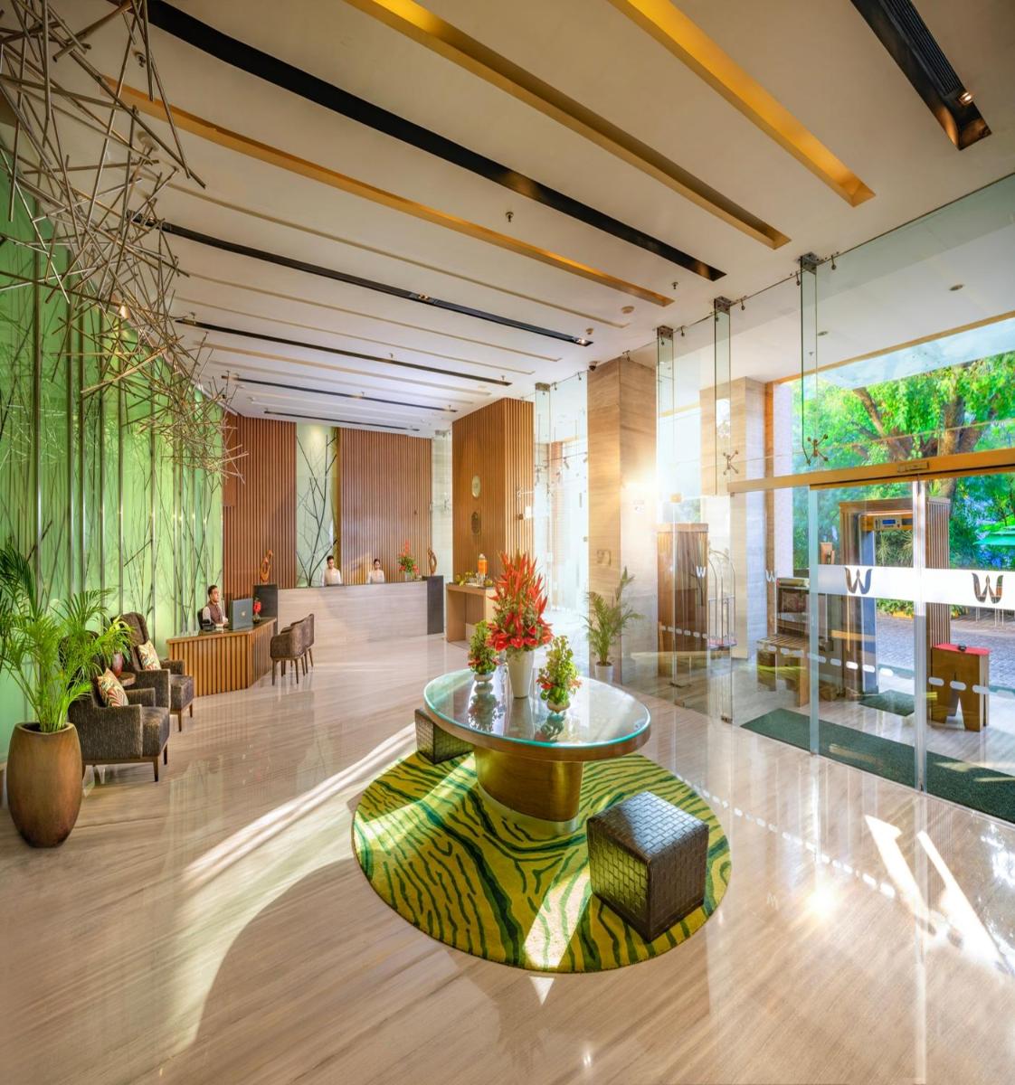 a lobby with a table in the middle of a building at Welcomhotel by ITC Hotels, Richmond Road, Bengaluru in Bengaluru