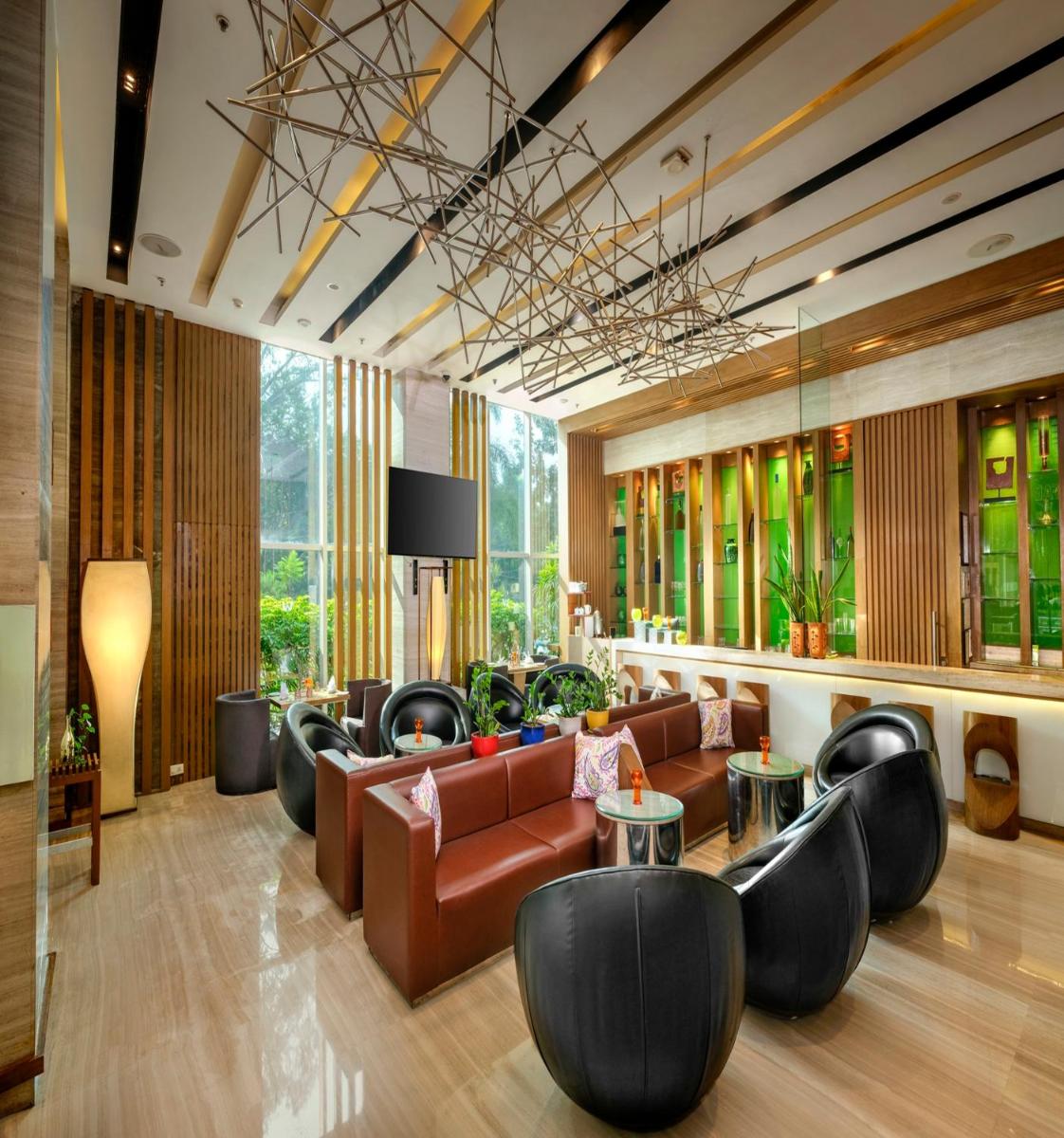 a lobby with leather couches and tables and windows at Welcomhotel by ITC Hotels, Richmond Road, Bengaluru in Bengaluru