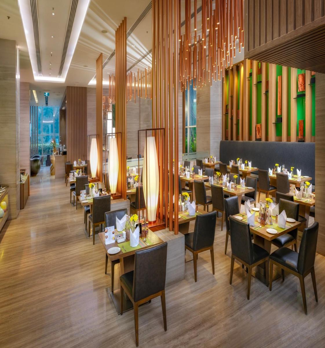 a dining room with tables and chairs in a restaurant at Welcomhotel by ITC Hotels, Richmond Road, Bengaluru in Bengaluru