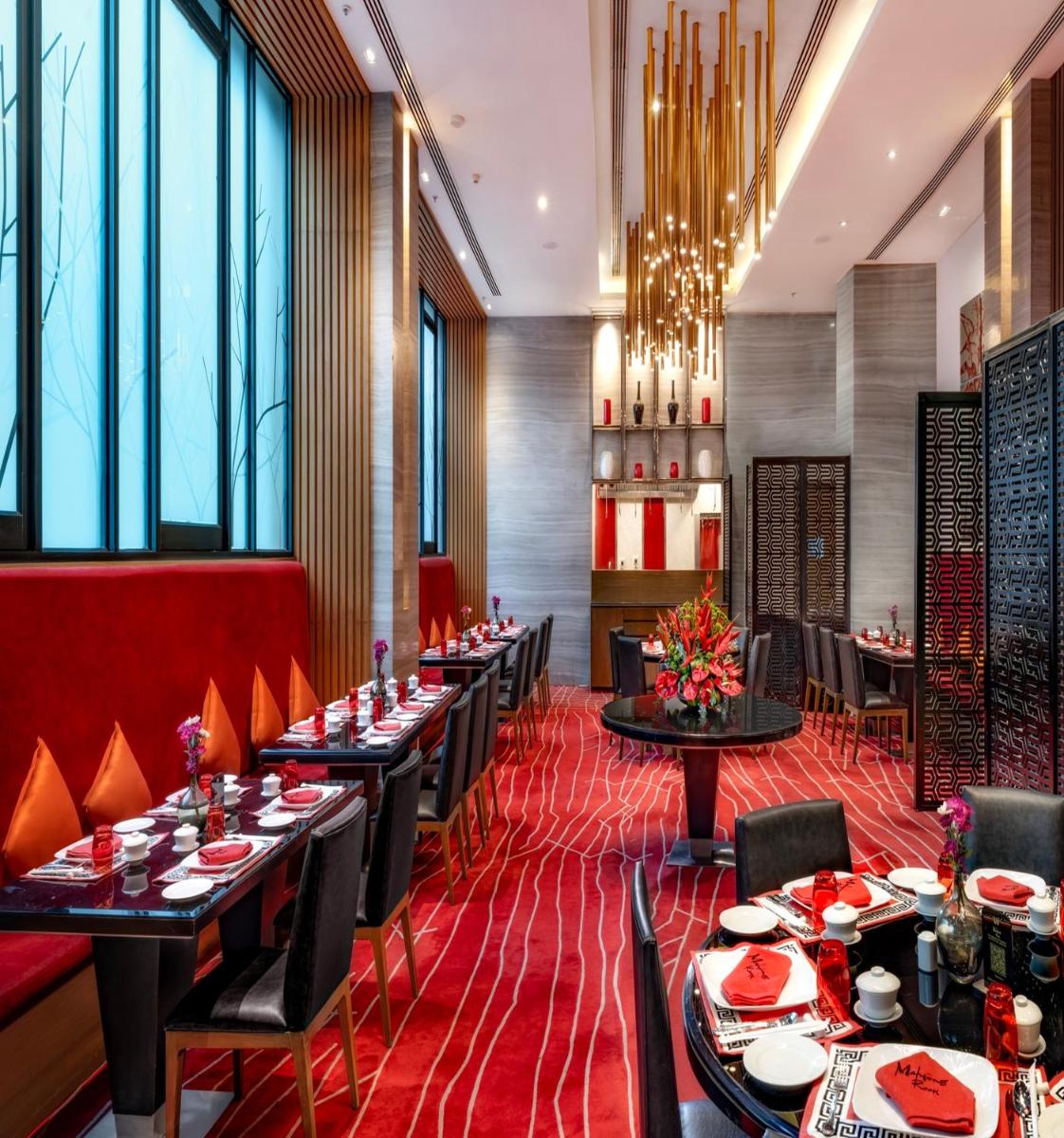 a dining room with tables and chairs and windows at Welcomhotel by ITC Hotels, Richmond Road, Bengaluru in Bengaluru