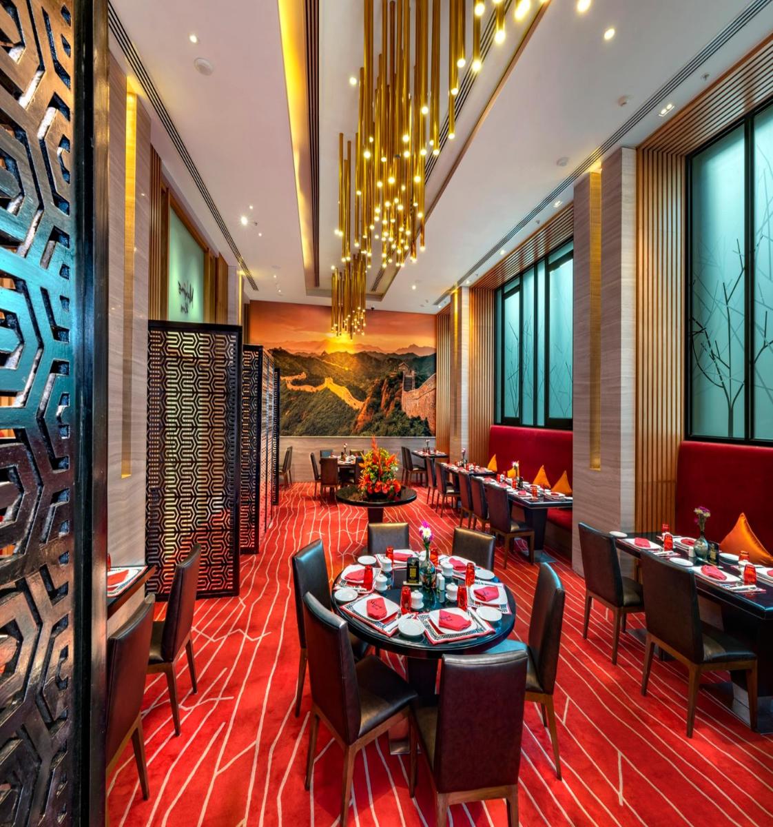 a dining room with tables and chairs and windows at Welcomhotel by ITC Hotels, Richmond Road, Bengaluru in Bengaluru