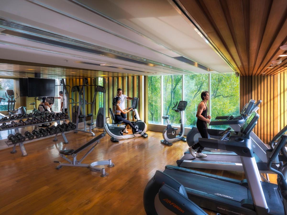 a gym with people exercising in machines in a room at Welcomhotel by ITC Hotels, Richmond Road, Bengaluru in Bengaluru