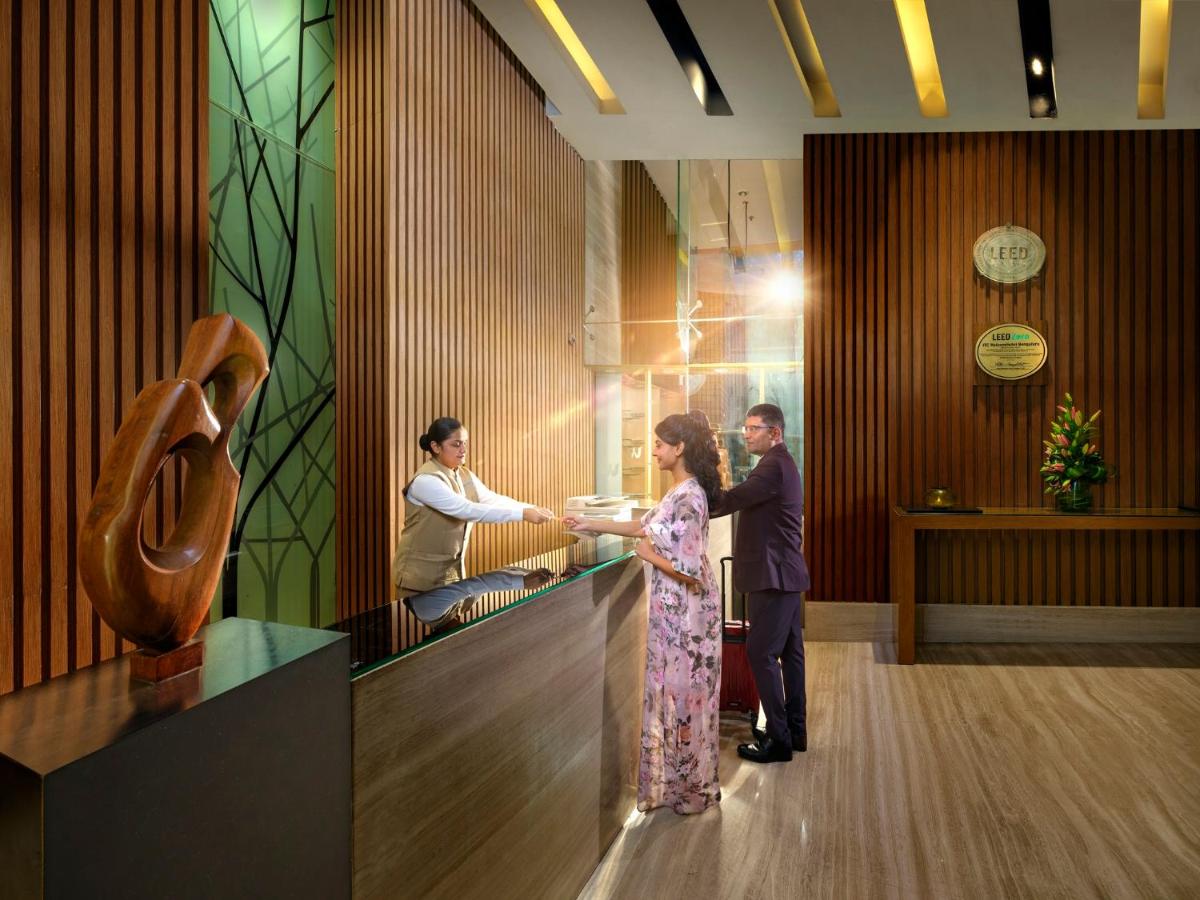 a man and a woman standing at a counter at Welcomhotel by ITC Hotels, Richmond Road, Bengaluru in Bengaluru
