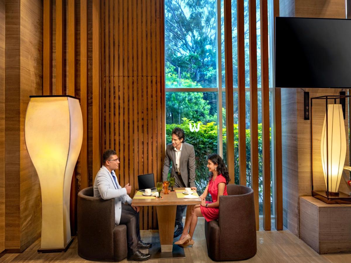 a group of people sitting around a table in a room at Welcomhotel by ITC Hotels, Richmond Road, Bengaluru in Bengaluru