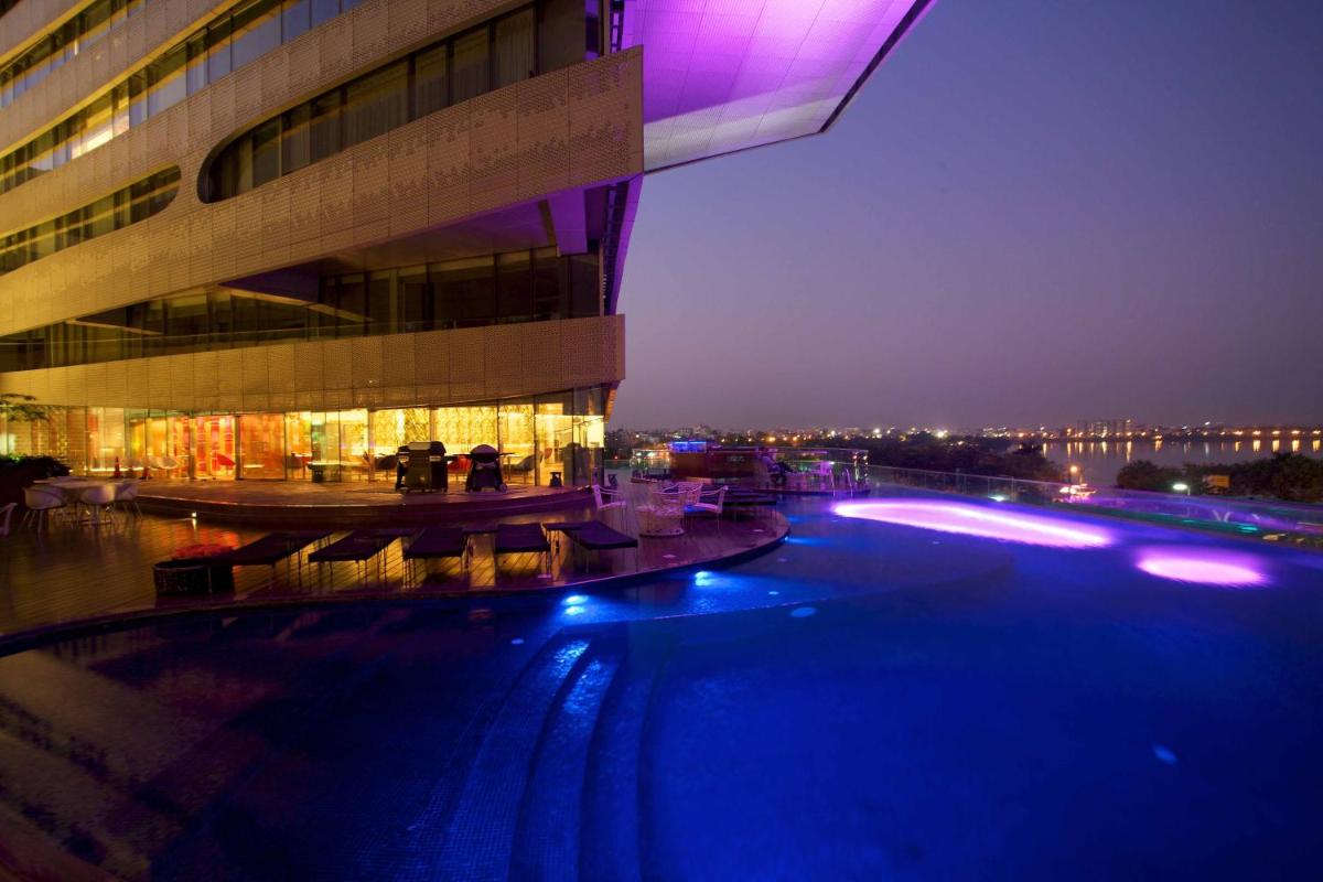 a large building with a swimming pool at night at The Park Hyderabad, Banjara Hills near Hussain Sagar Lake in Hyderabad a large building with a swimming pool at night at The Park Hyderabad, Banjara Hills near Hussain Sagar Lake in Hyderabad