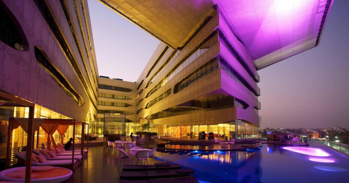 a building with a pool and tables and chairs at The Park Hyderabad, Banjara Hills near Hussain Sagar Lake in Hyderabad a building with a pool and tables and chairs at The Park Hyderabad, Banjara Hills near Hussain Sagar Lake in Hyderabad