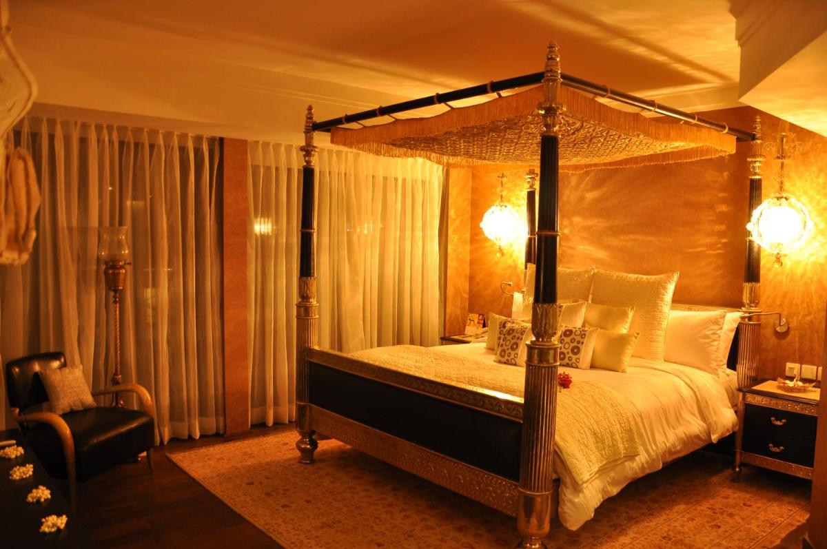 a bedroom with a canopy bed and a chair at The Park Hyderabad, Banjara Hills near Hussain Sagar Lake in Hyderabad a bedroom with a canopy bed and a chair at The Park Hyderabad, Banjara Hills near Hussain Sagar Lake in Hyderabad