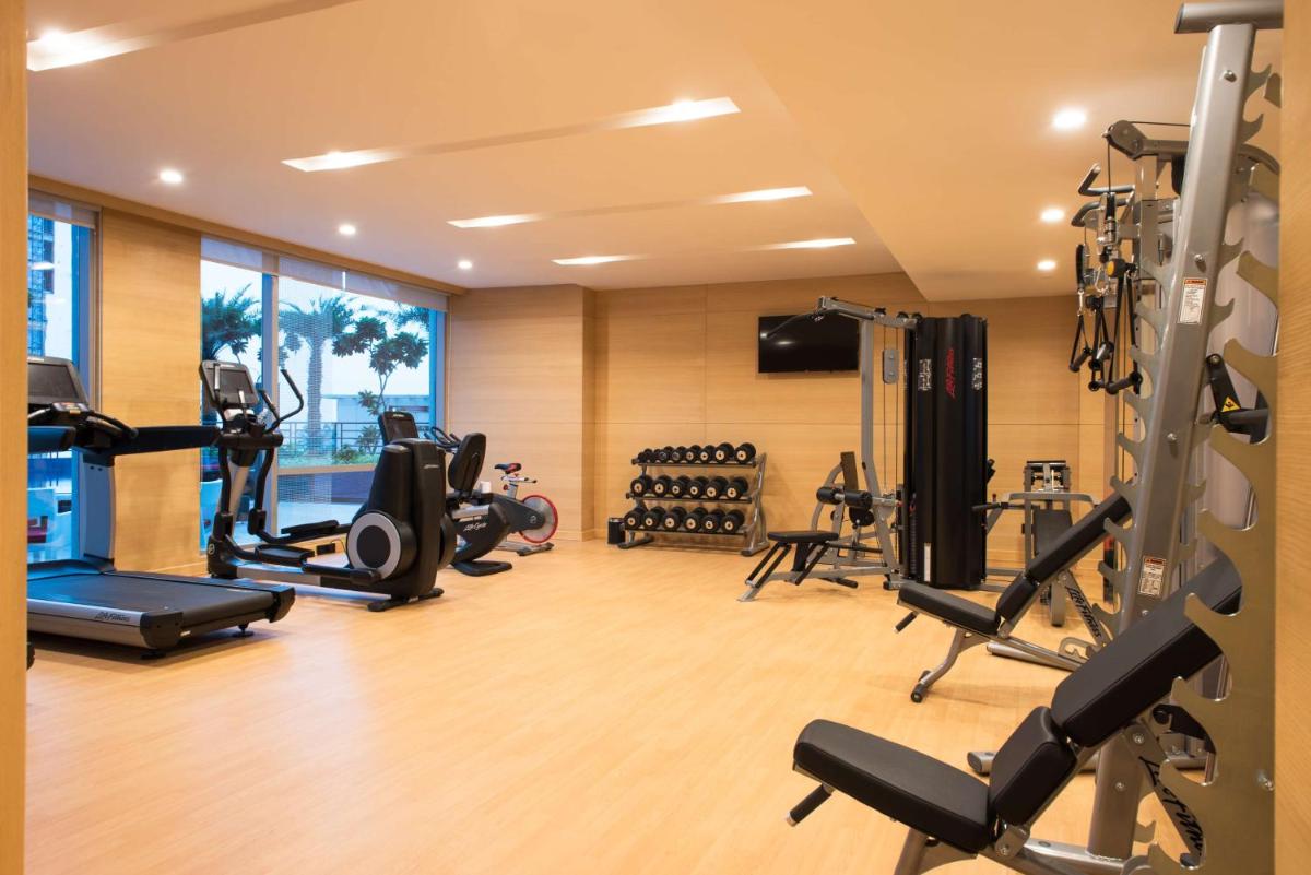 a gym with several treadmills and machines in a room at Hyatt Regency Lucknow Gomti Nagar in Lucknow