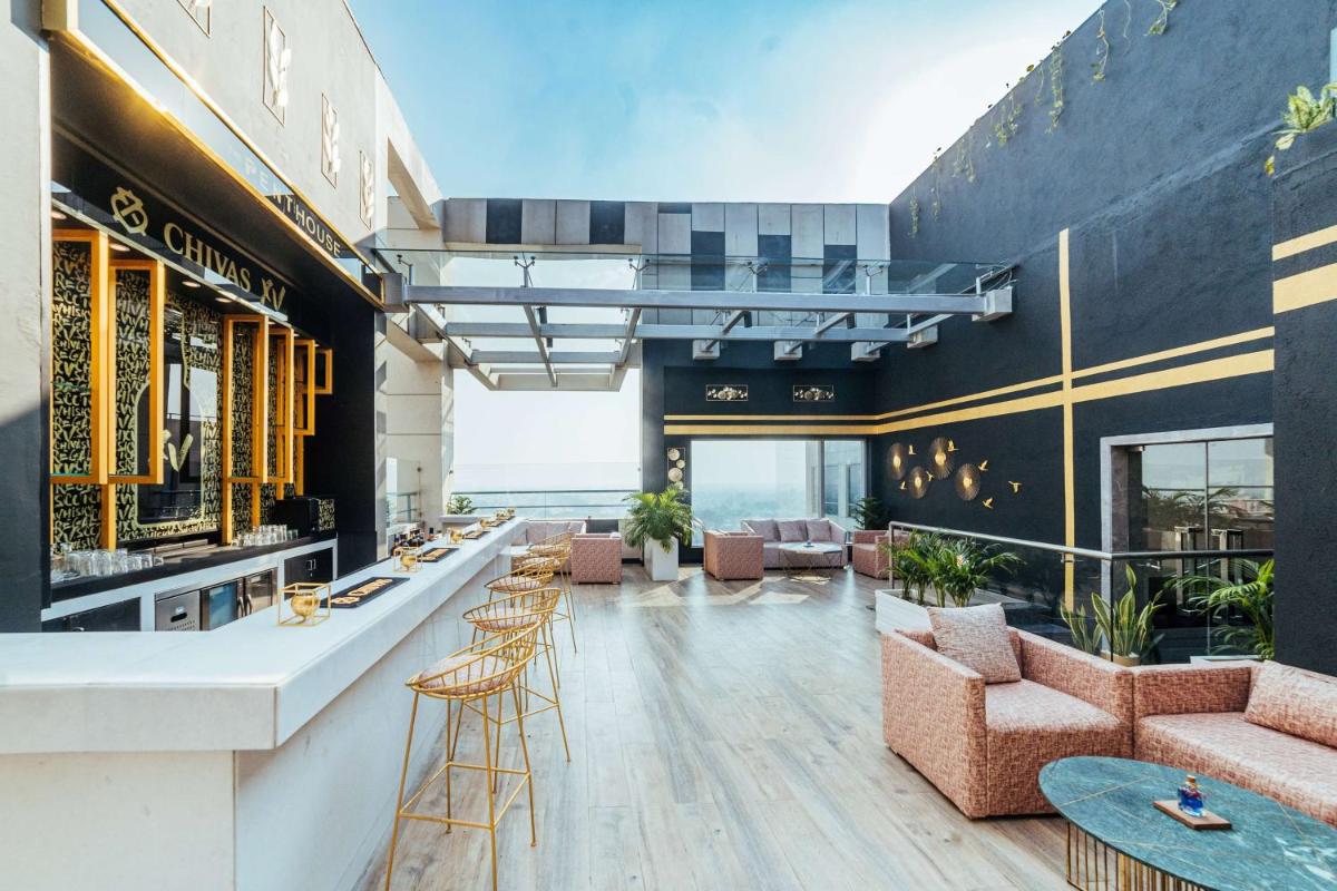 a lobby with a bar and chairs and tables at Hyatt Regency Lucknow Gomti Nagar in Lucknow