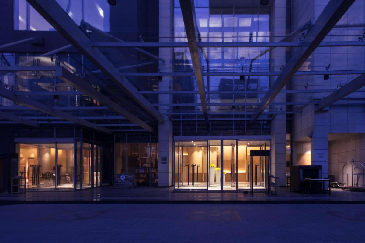 a large building with glass doors andwindows at night at Hyatt Regency Lucknow Gomti Nagar in Lucknow