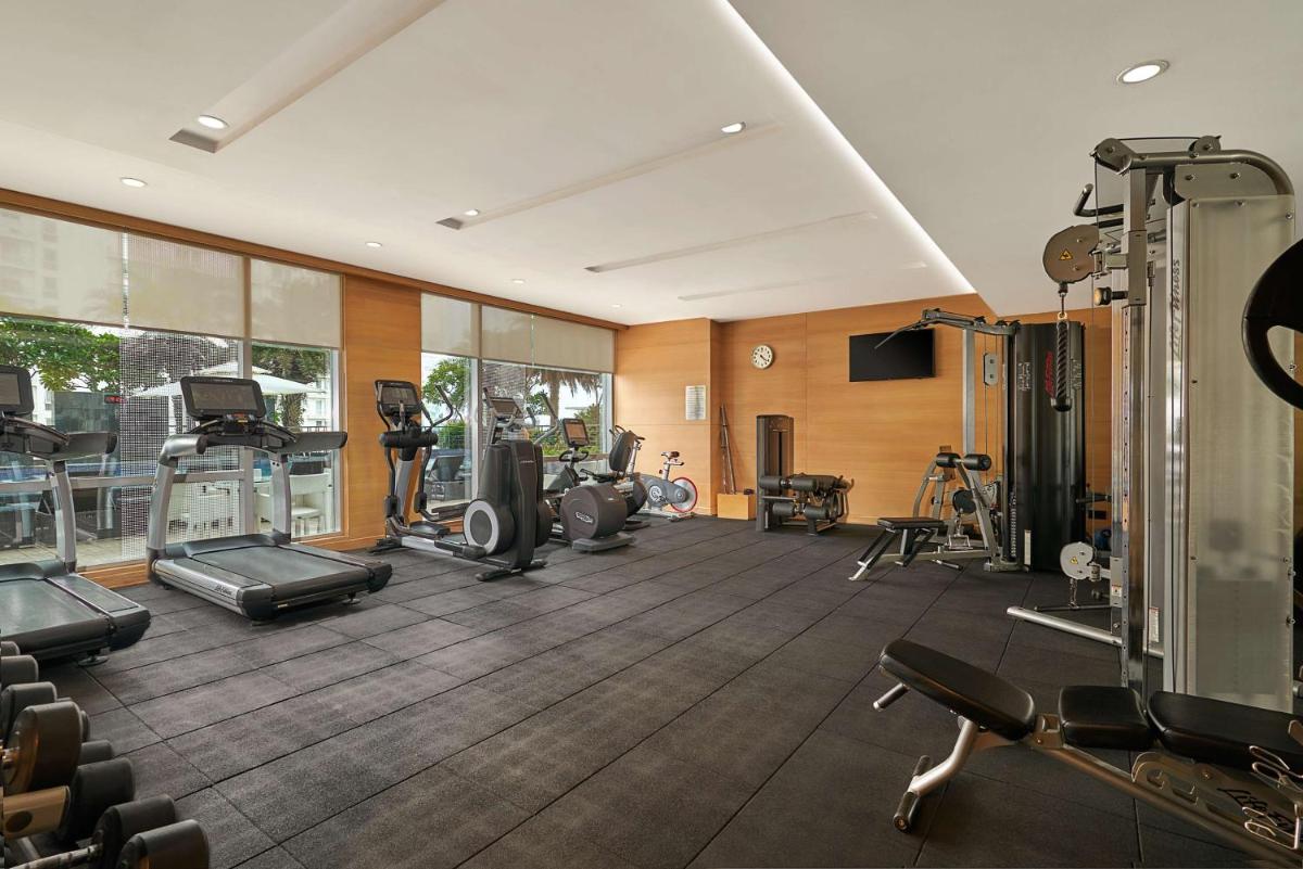 a gym with several treadmills and exercise equipment at Hyatt Regency Lucknow Gomti Nagar in Lucknow