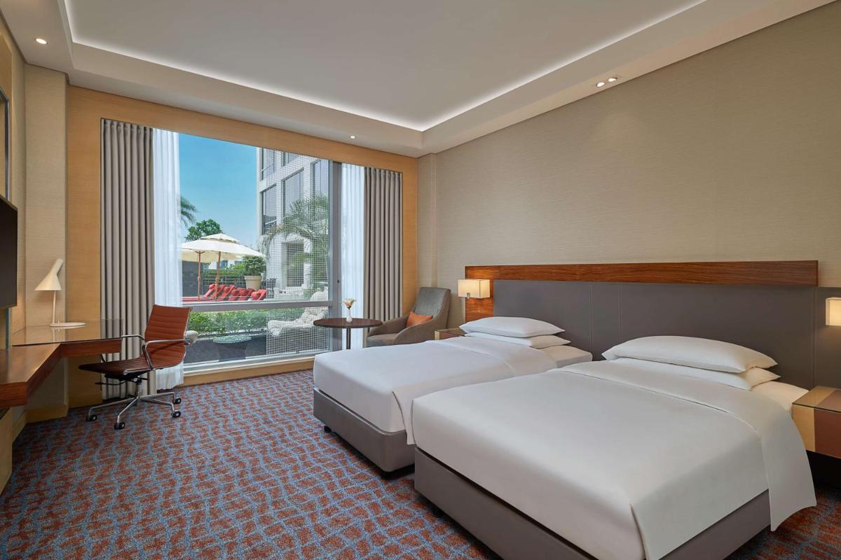 a hotel room with two beds and a desk at Hyatt Regency Lucknow Gomti Nagar in Lucknow
