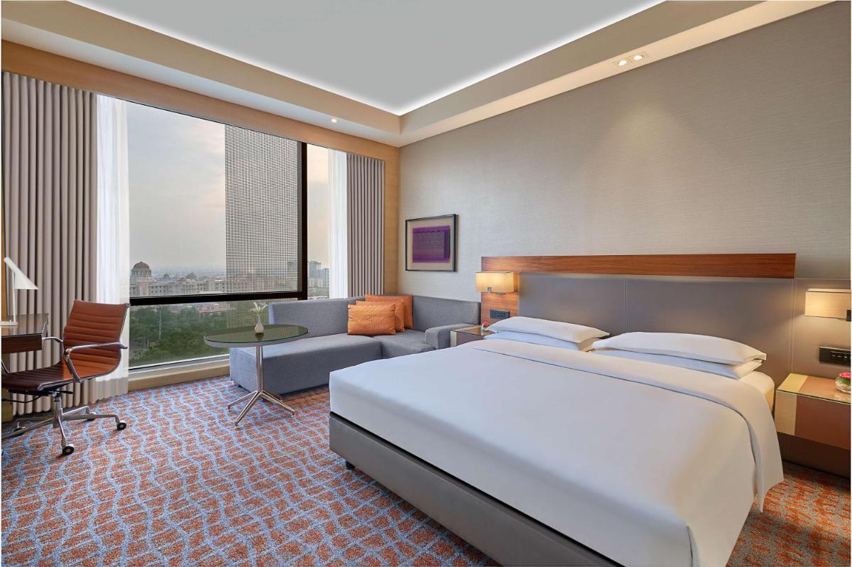 a hotel room with a large bed and a couch at Hyatt Regency Lucknow Gomti Nagar in Lucknow