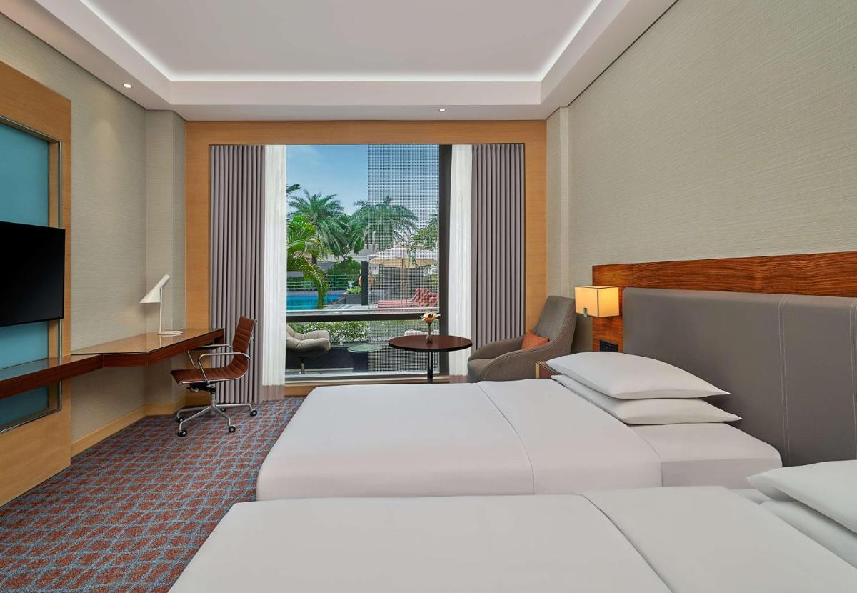 a hotel room with two beds and a television at Hyatt Regency Lucknow Gomti Nagar in Lucknow