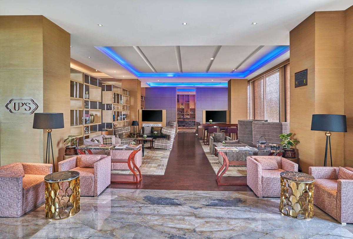 a lobby with couches and chairs in a building at Hyatt Regency Lucknow Gomti Nagar in Lucknow