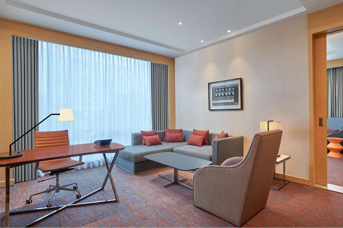 a living room with a couch and a desk in a hotel room at Hyatt Regency Lucknow Gomti Nagar in Lucknow