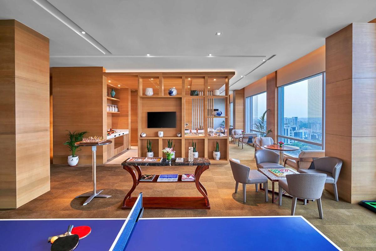 a living room with a table and some chairs at Hyatt Regency Lucknow Gomti Nagar in Lucknow