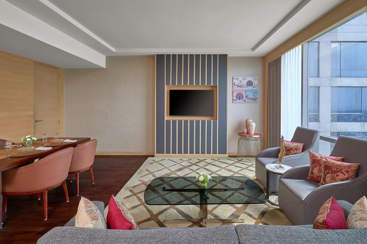 a living room with a couch and a table and a television at Hyatt Regency Lucknow Gomti Nagar in Lucknow