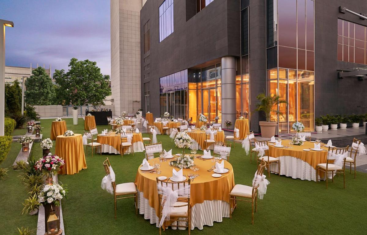 a banquet hall with tables and chairs in front of a building at Hyatt Regency Lucknow Gomti Nagar in Lucknow +137 photos