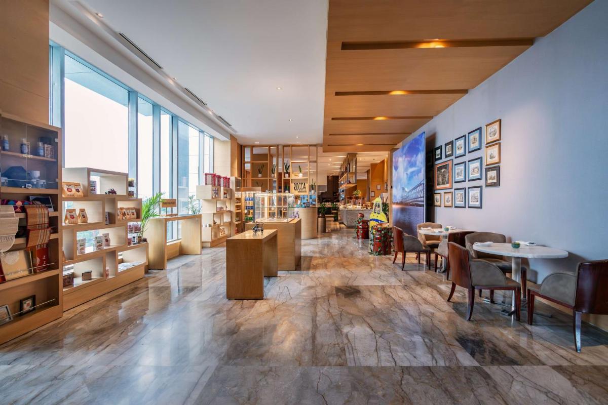 a restaurant with tables and chairs in a room at Hyatt Regency Lucknow Gomti Nagar in Lucknow
