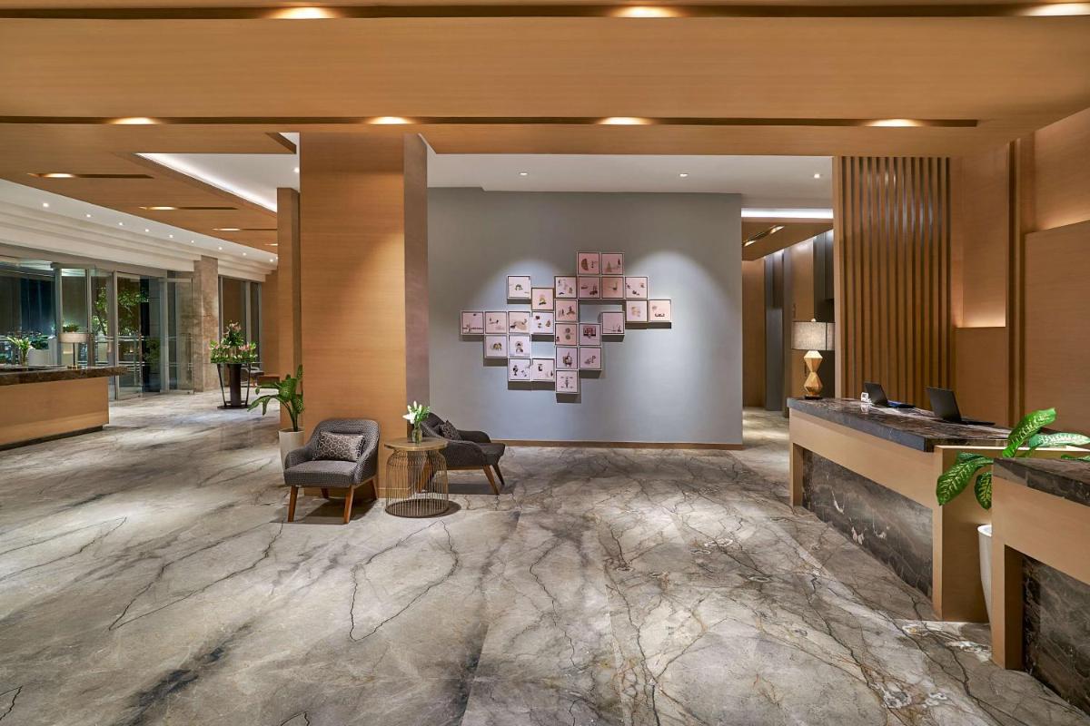 a lobby of a hotel with chairs and a wall at Hyatt Regency Lucknow Gomti Nagar in Lucknow