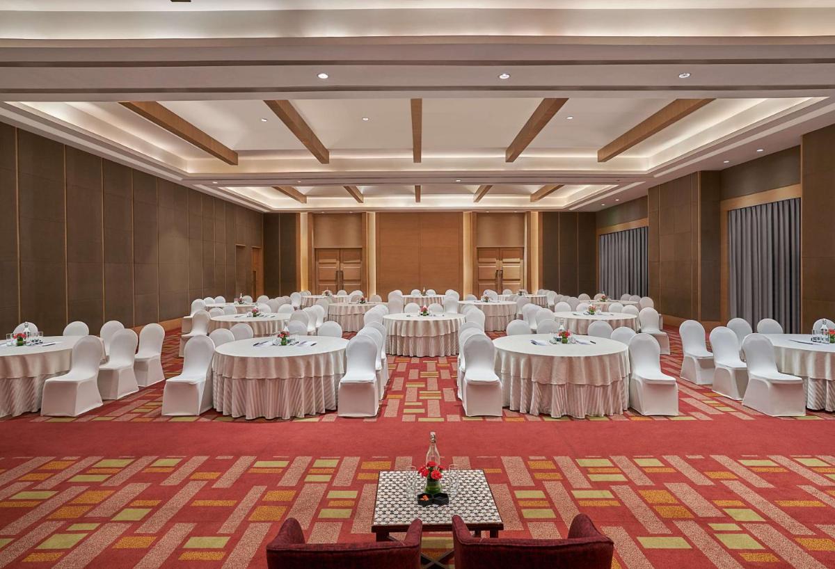 a large banquet hall with white tables and chairs at Hyatt Regency Lucknow Gomti Nagar in Lucknow