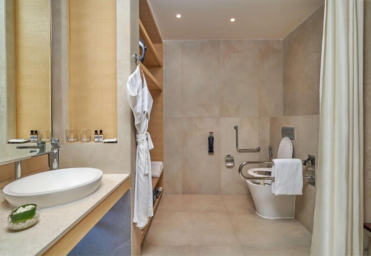 a bathroom with a toilet and a sink at Hyatt Regency Lucknow Gomti Nagar in Lucknow
