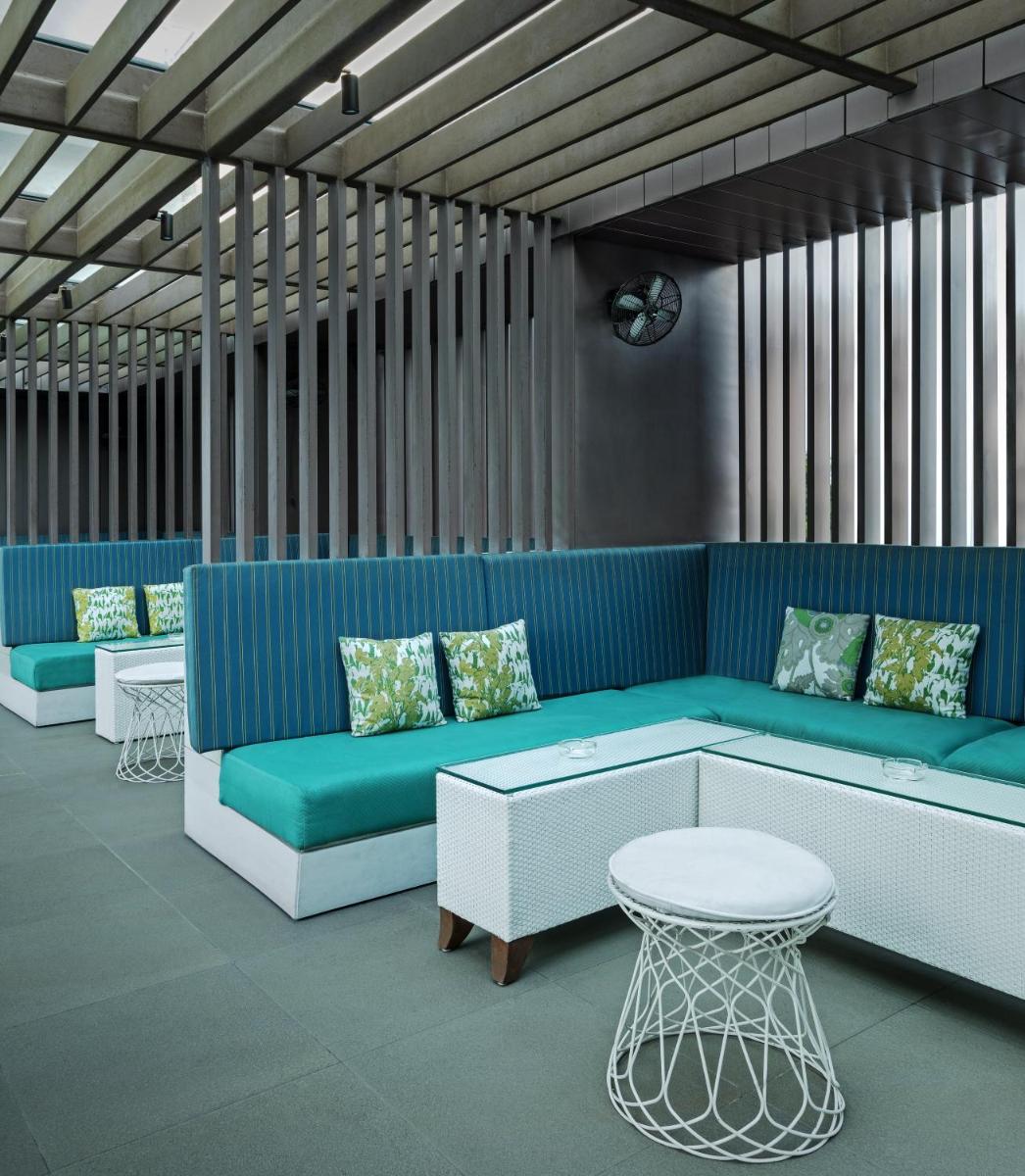a waiting area with a blue couch and a table at The Park Kolkata in Kolkata