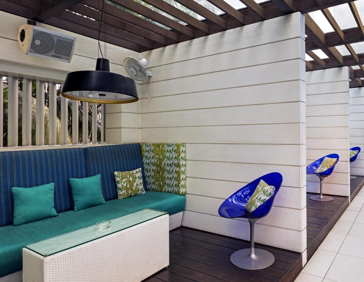 a patio with a blue couch and two chairs at The Park Kolkata in Kolkata