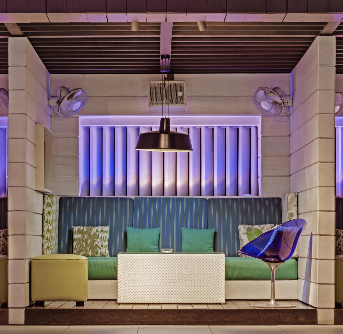 a room with a couch and chairs and a lamp at The Park Kolkata in Kolkata