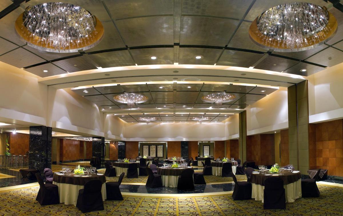a banquet hall with tables and chandeliers at The Park Kolkata in Kolkata +56 photos