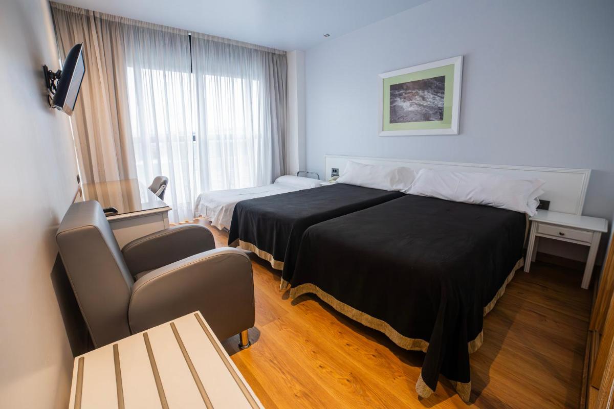 Cama o camas de una habitación en Hotel Auditorio Santiago & Spa