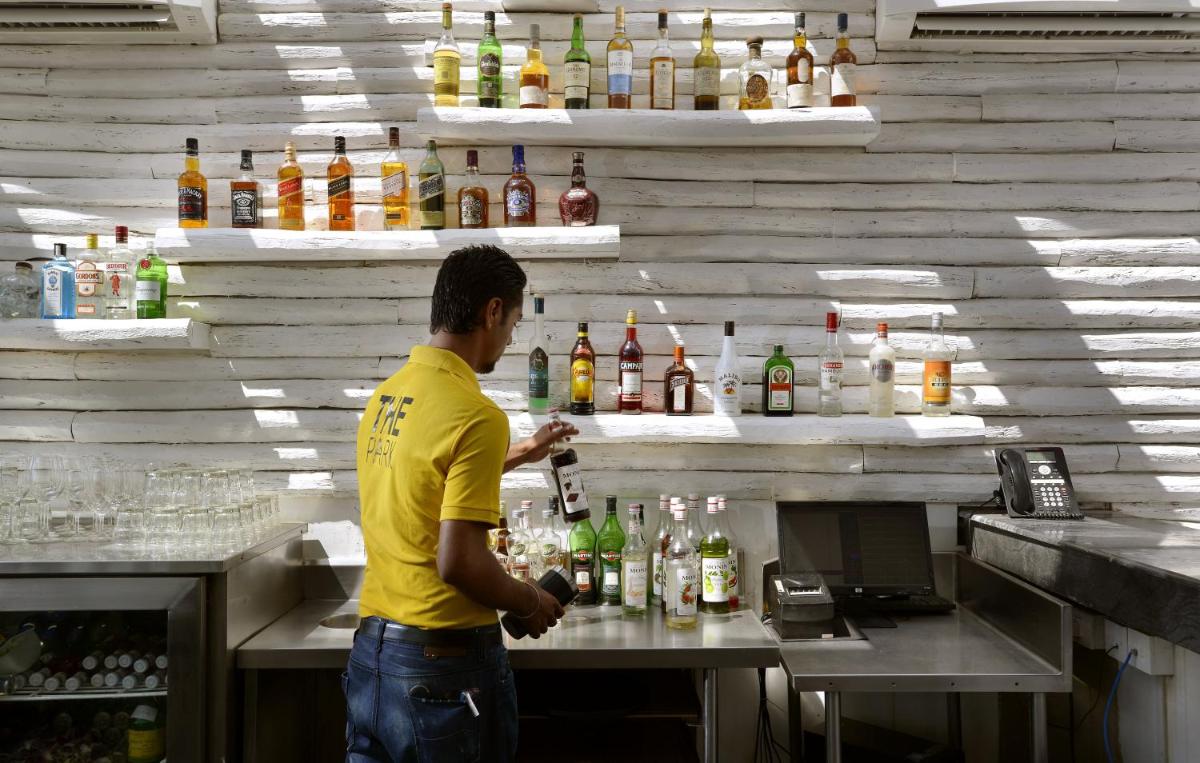a man making a drink at a bar at The Park Calangute Goa in Calangute a man making a drink at a bar at The Park Calangute Goa in Calangute