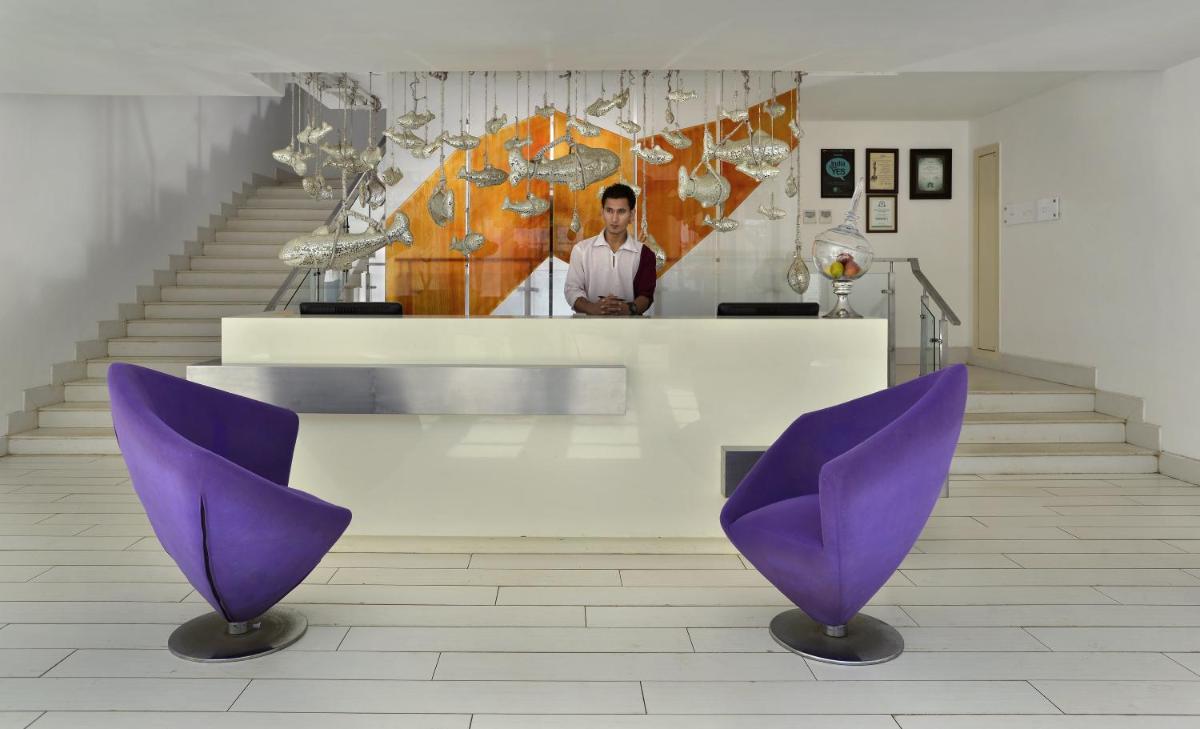 two purple chairs sitting in a room with stairs at The Park Calangute Goa in Calangute two purple chairs sitting in a room with stairs at The Park Calangute Goa in Calangute