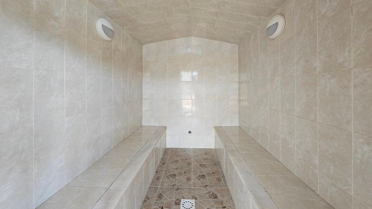 uma casa de banho com um grande chuveiro com azulejos de mármore em Browns Sports Resort em Vilamoura