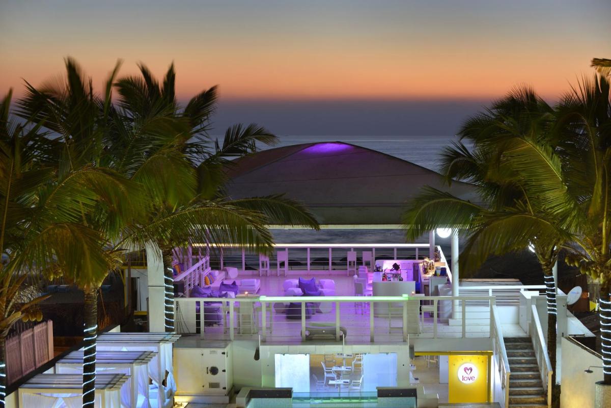 a view of a resort with palm trees and purple lighting at The Park Calangute Goa in Calangute a view of a resort with palm trees and purple lighting at The Park Calangute Goa in Calangute