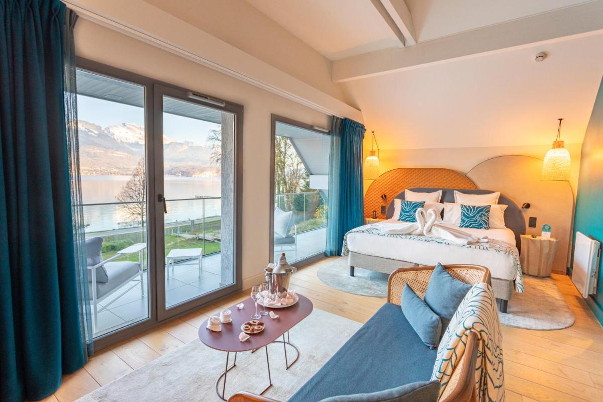une chambre avec un lit et une grande fenêtre dans l'établissement Black Bass Hotel, à Sévrier