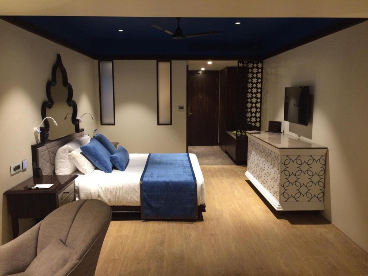 a bedroom with a bed and a couch and a television at Hotel Lakend in Udaipur