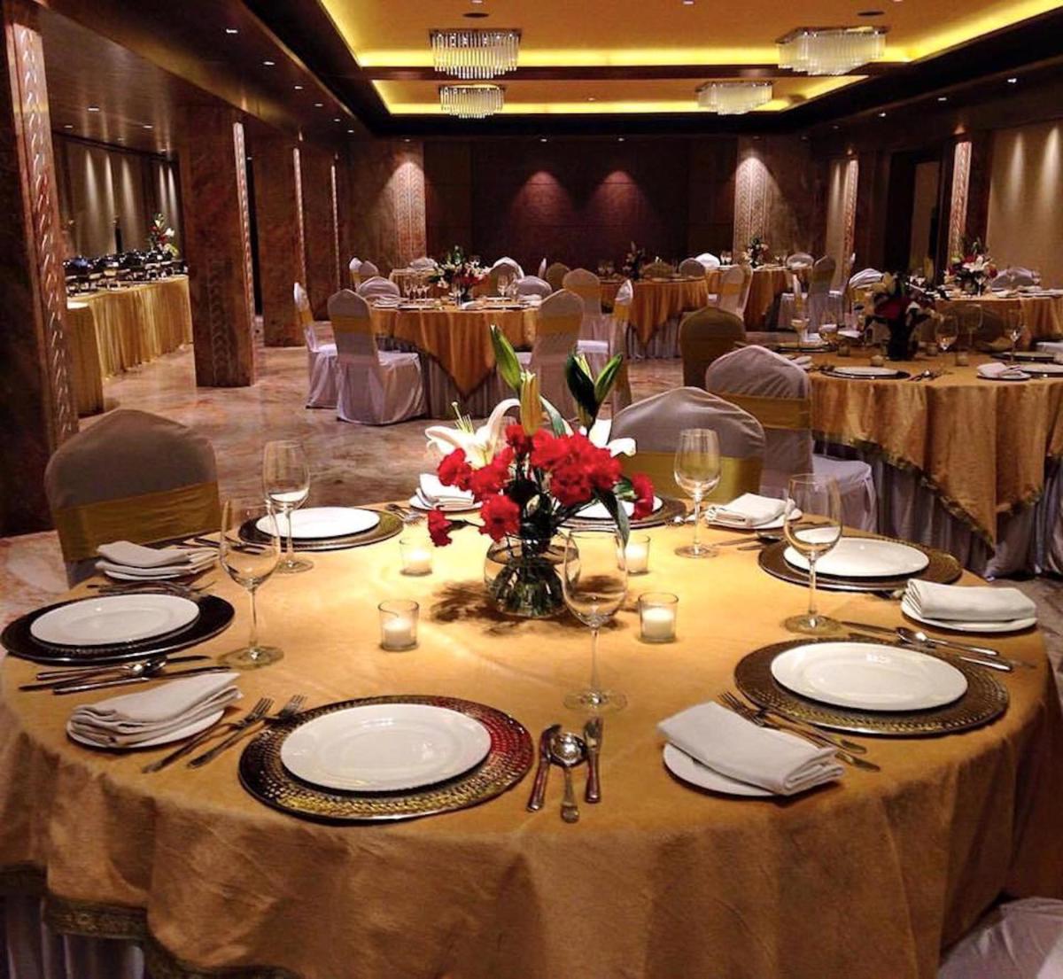 a dining room with a table with plates and glasses at Hotel Lakend in Udaipur
