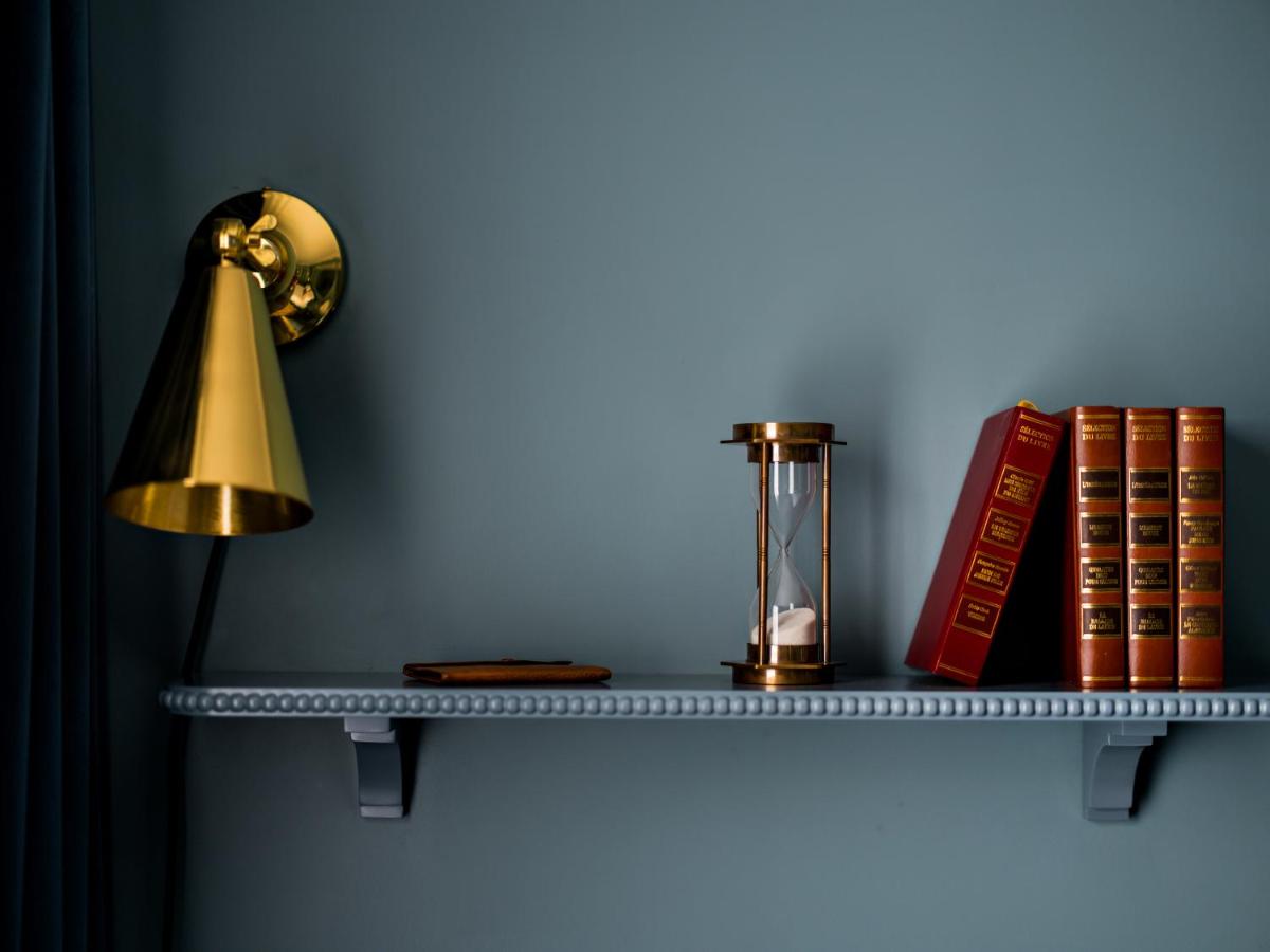 une étagère avec une lampe et des livres sur un mur dans l'établissement Hotel Duquesne Eiffel, à Paris